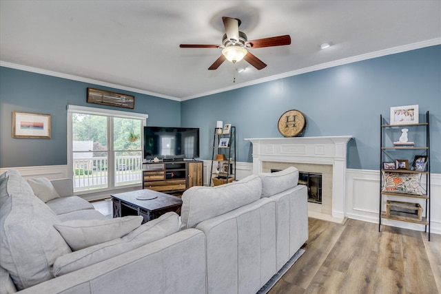 32 Creekside Dr, Aiken, SC 29803 - living room with a ceiling fan, crown molding, a premium fireplace, a wainscoted wall, and wood finished floors