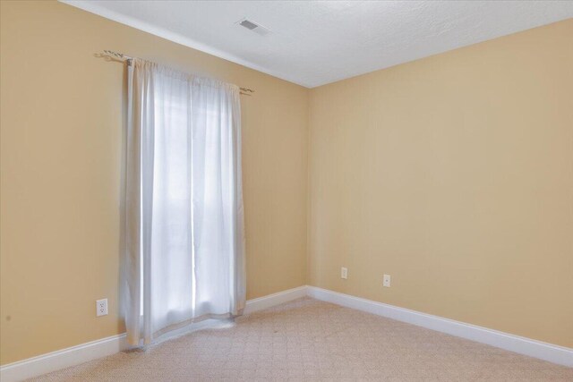 carpeted empty room with baseboards and visible vents