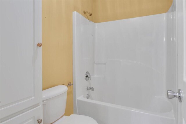 bathroom featuring toilet and washtub / shower combination