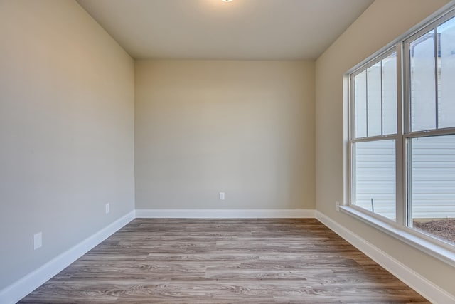 unfurnished room featuring baseboards and wood finished floors