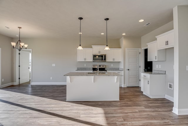 kitchen featuring stainless steel appliances, dark wood-style flooring, visible vents, and white cabinets