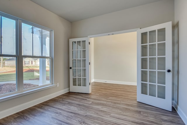 unfurnished room with french doors, wood finished floors, and baseboards