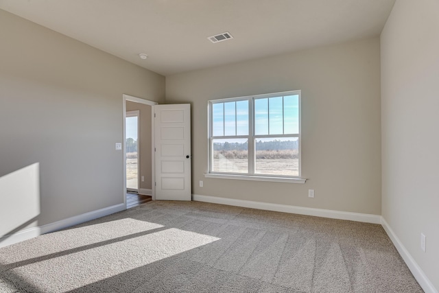 carpeted empty room with visible vents and baseboards