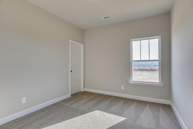 unfurnished room featuring carpet floors, visible vents, and baseboards