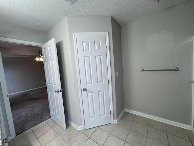 bathroom with tile patterned flooring, ceiling fan, and a textured ceiling