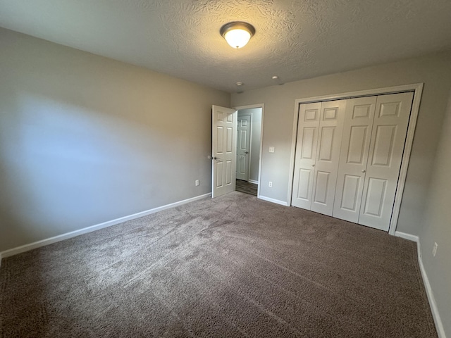 unfurnished bedroom with carpet floors, a textured ceiling, and a closet