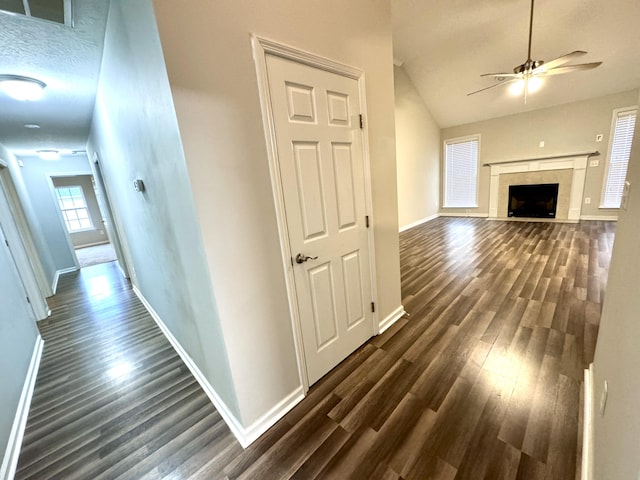 hall featuring dark hardwood / wood-style floors, lofted ceiling, and a textured ceiling