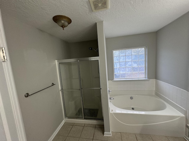 bathroom featuring tile patterned floors, separate shower and tub, and a textured ceiling