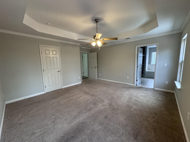 unfurnished bedroom with carpet, connected bathroom, a raised ceiling, and ceiling fan