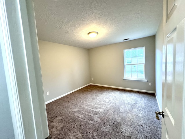 unfurnished room featuring dark carpet and a textured ceiling