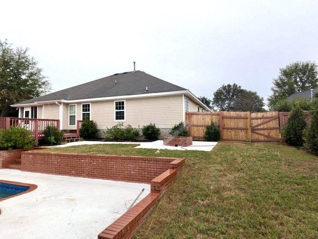 rear view of house featuring a lawn, a swimming pool side deck, and a patio