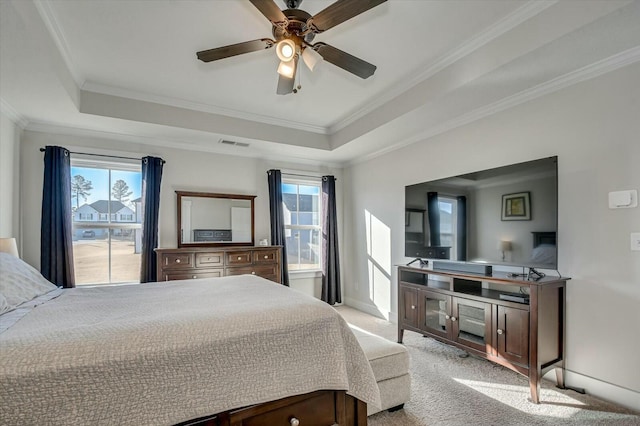 bedroom featuring a raised ceiling, ornamental molding, light carpet, and ceiling fan