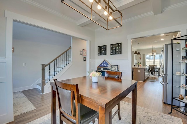 dining room with an inviting chandelier, hardwood / wood-style floors, and ornamental molding