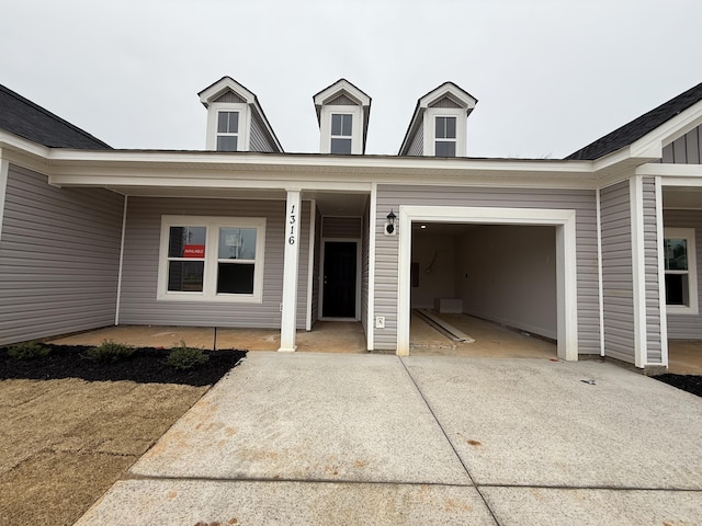 view of exterior entry with a garage and concrete driveway