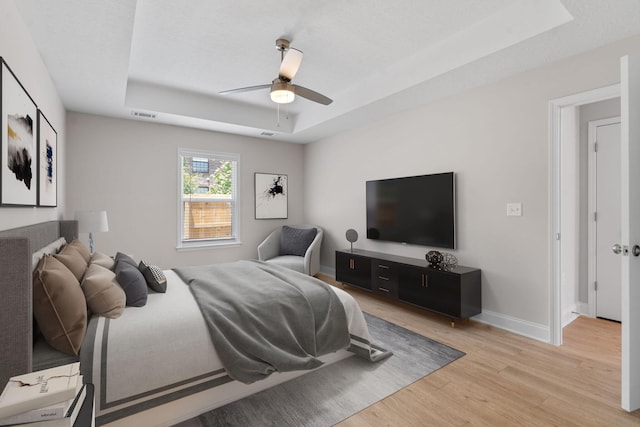 2247 Archer Ln, Augusta, GA 30906 - bedroom with a tray ceiling, light wood finished floors, and a ceiling fan
