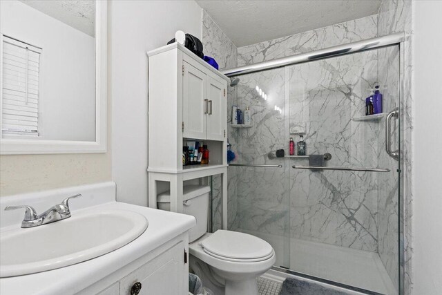 3639 Massoit Dr, Augusta, GA 30906 - bathroom featuring a marble finish shower, vanity, toilet, and a textured ceiling