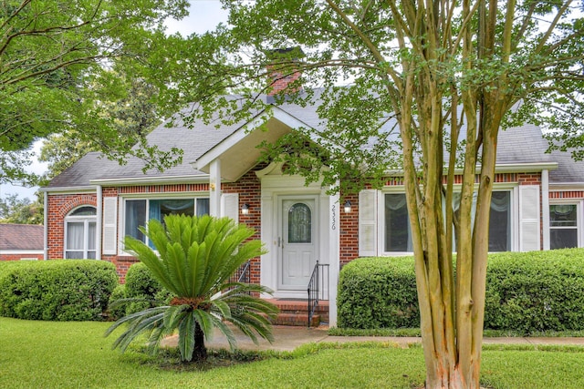2336 Redwood Dr, Augusta, GA 30904 - view of front facade with brick siding, a front lawn, a shingled roof, and a chimney