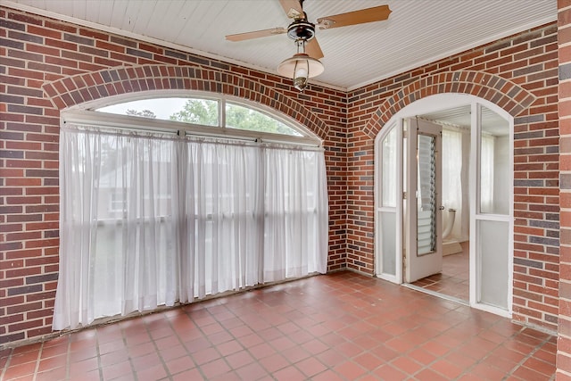 2336 Redwood Dr, Augusta, GA 30904 - spare room featuring tile patterned floors, brick wall, ceiling fan, and arched walkways