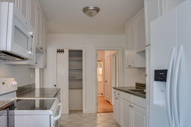 2336 Redwood Dr, Augusta, GA 30904 - kitchen featuring white appliances, light tile patterned floors, dark countertops, and white cabinetry