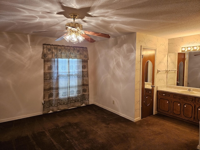 spare room featuring dark colored carpet, ceiling fan, and sink