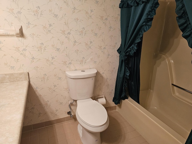 bathroom featuring tile patterned floors, toilet, and shower / bathtub combination with curtain