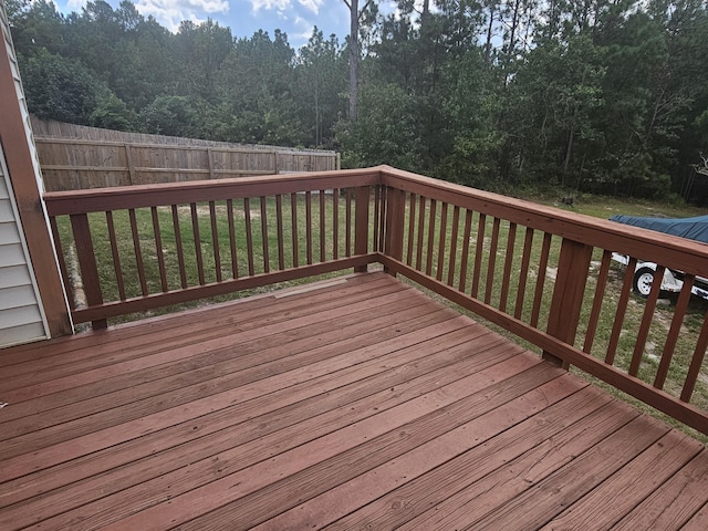 wooden terrace featuring a lawn