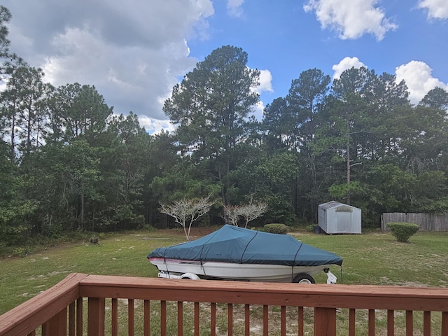 deck featuring a storage unit and a yard