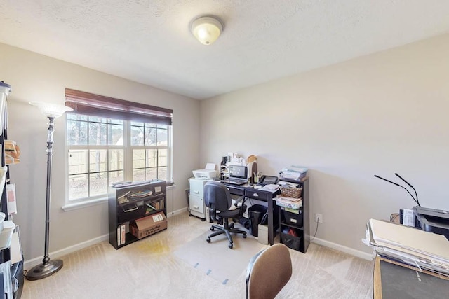 office with baseboards, light colored carpet, and a textured ceiling