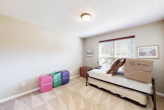 bedroom with baseboards, carpet floors, and a textured ceiling