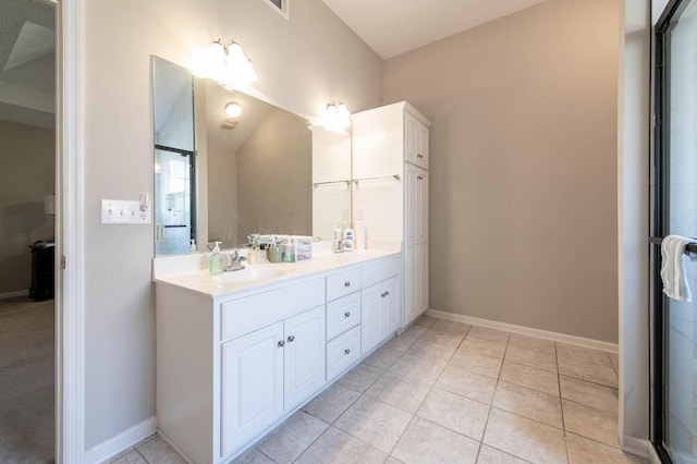 bathroom with a sink, baseboards, double vanity, and tile patterned flooring