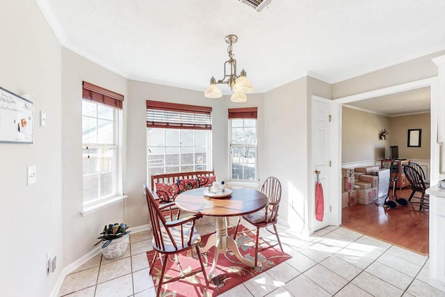 dining area featuring a wealth of natural light, crown molding, an inviting chandelier, and light tile patterned flooring