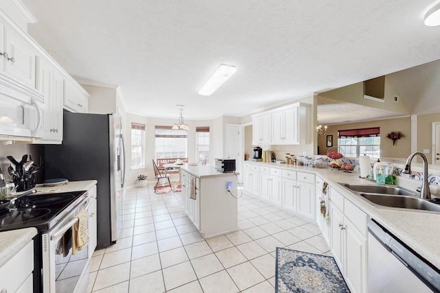 kitchen with dishwashing machine, light tile patterned floors, a sink, electric stove, and a chandelier