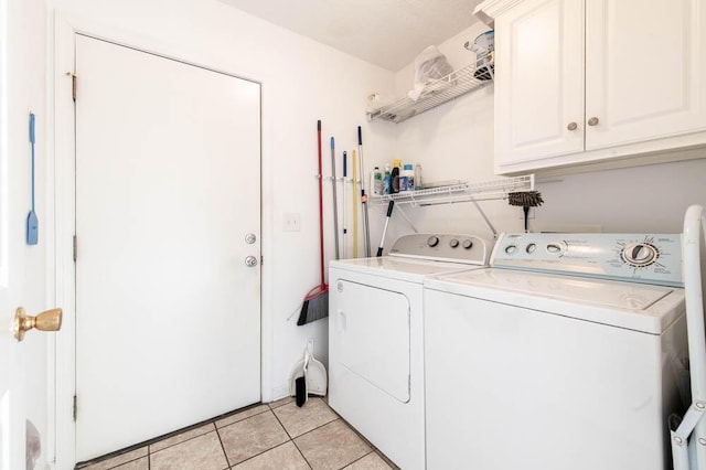 clothes washing area featuring light tile patterned floors, cabinet space, and independent washer and dryer