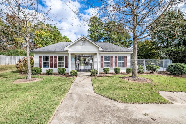 view of front of home featuring a front lawn, fence, and roof with shingles