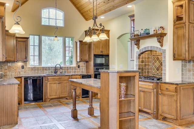 kitchen with black appliances, sink, a kitchen island, and pendant lighting