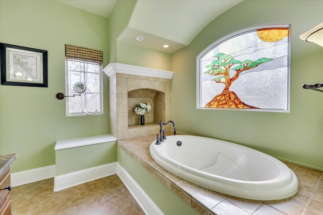 bathroom featuring vanity, lofted ceiling, and a bathing tub