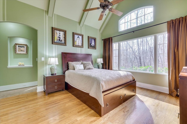 bedroom featuring ceiling fan, light hardwood / wood-style flooring, beamed ceiling, and high vaulted ceiling