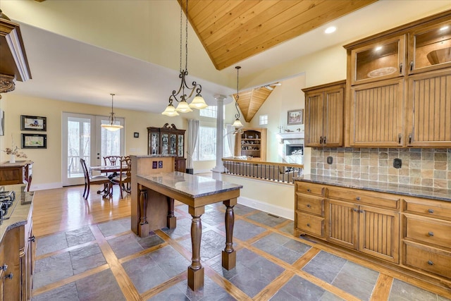 kitchen featuring lofted ceiling, decorative backsplash, plenty of natural light, hanging light fixtures, and wooden ceiling