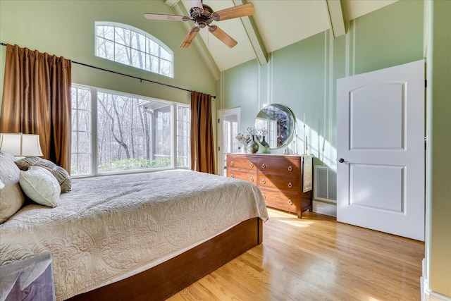 bedroom with high vaulted ceiling, light hardwood / wood-style flooring, beam ceiling, and ceiling fan