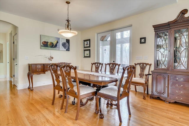 dining area with light wood-type flooring and french doors