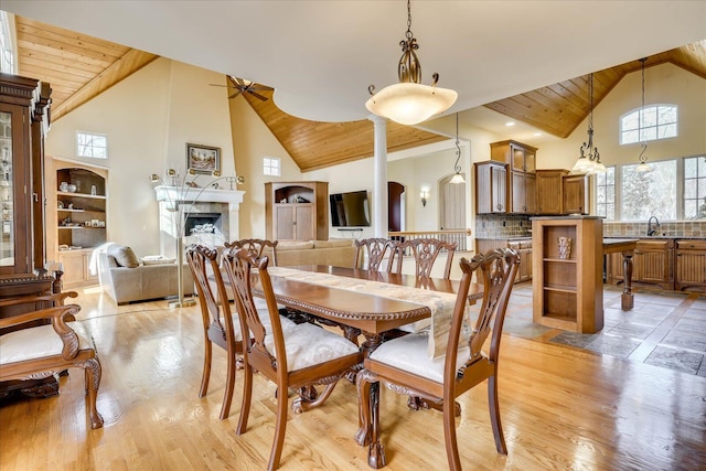 dining space with light hardwood / wood-style floors, wooden ceiling, ceiling fan, high vaulted ceiling, and sink