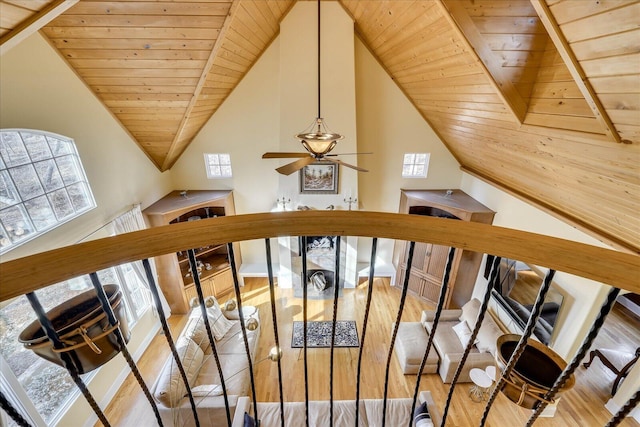 stairway with ceiling fan, wood-type flooring, wood ceiling, and a fireplace