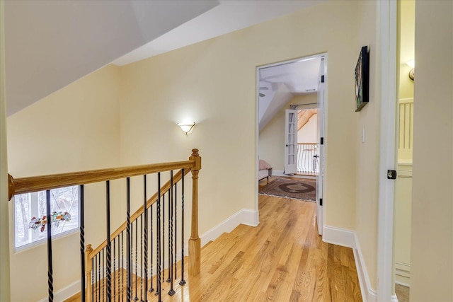 corridor with vaulted ceiling and light hardwood / wood-style flooring