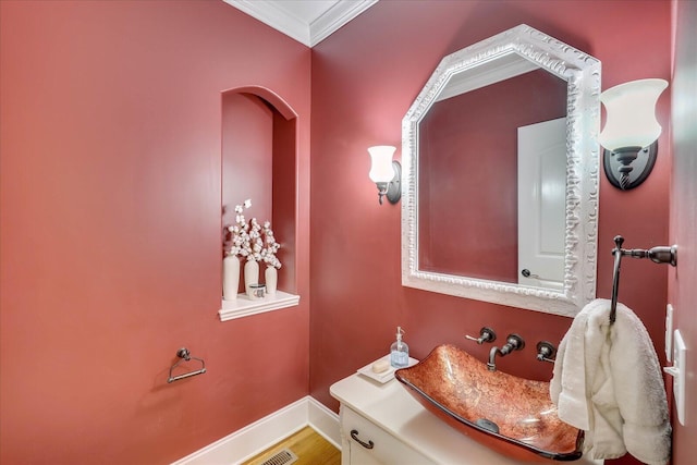 bathroom featuring crown molding, hardwood / wood-style flooring, and sink