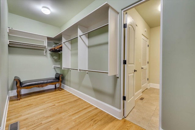 walk in closet with light wood-type flooring