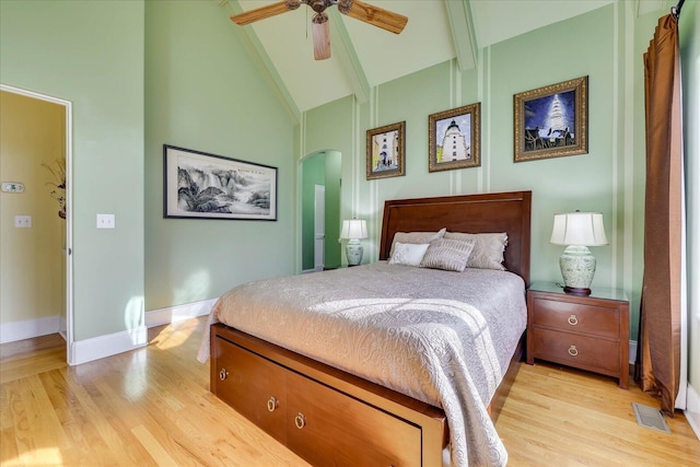 bedroom with ceiling fan, light hardwood / wood-style floors, high vaulted ceiling, and beamed ceiling