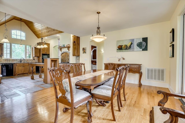 dining room with wood ceiling, vaulted ceiling with beams, light hardwood / wood-style floors, sink, and a notable chandelier