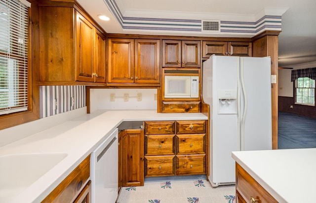 kitchen with crown molding, sink, and white appliances