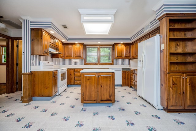 kitchen with a center island, white appliances, and ornamental molding