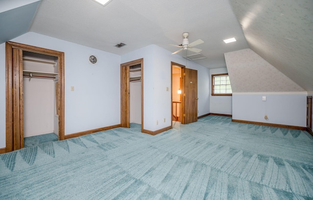 unfurnished bedroom with a textured ceiling, light colored carpet, and ceiling fan